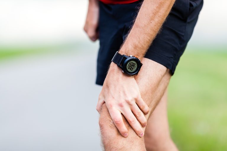 A runner holding his knee in pain.