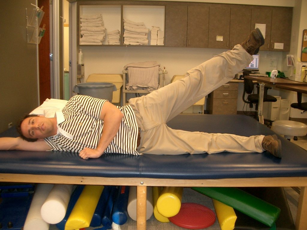 A PT tech performing a side lying hip abduction.