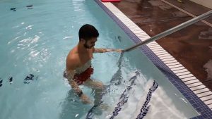 A demonstration of a step up exercise done on a pool step.