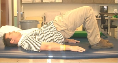 A demonstration of a glute bridge for back pain relief.