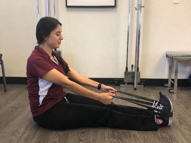 The start position for a seated exercise band row.