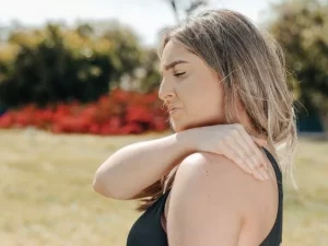 A woman experiencing shoulder pain.