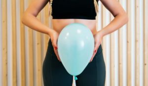 A woman holding a balloon experiencing the benefits of pelvic floor therapy.