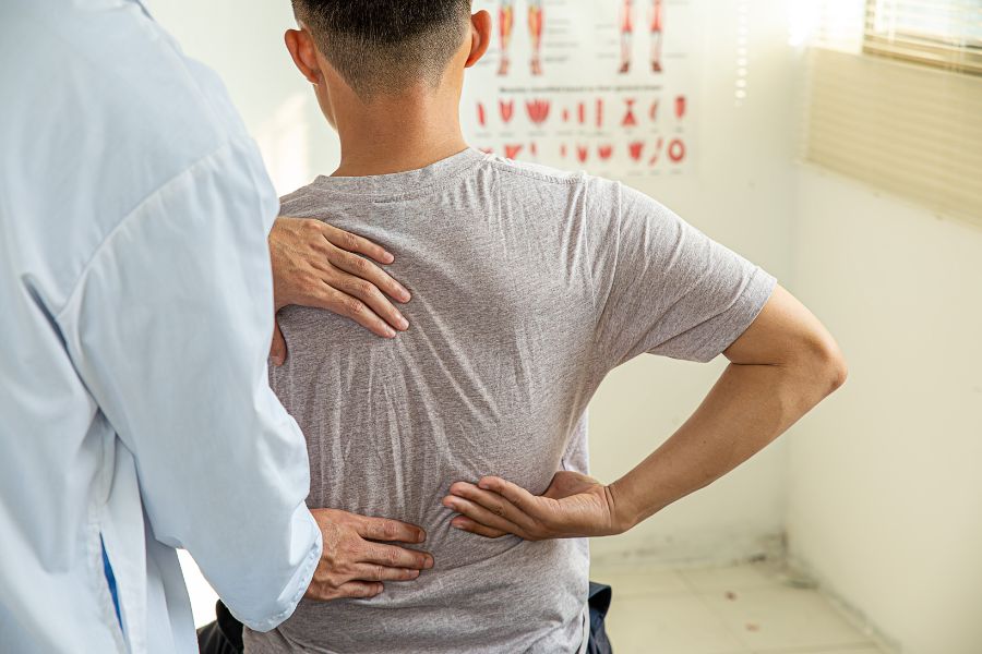 A patient being seen by a physical therapist for back pain.