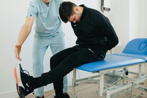 A man doing a nerve flossing exercise with a physical therapist.