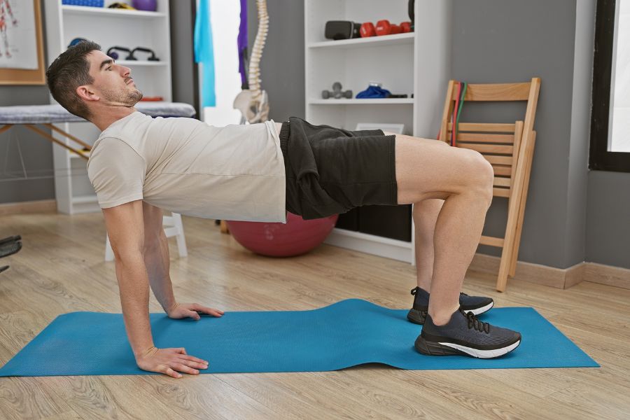 A patient engaging in a prehab exercise for the posterior chain.
