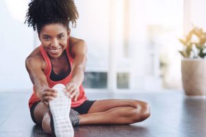 A woman performing a single leg hamstring stretch.