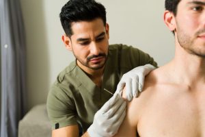 A physical therapy tech dry needling a patient.